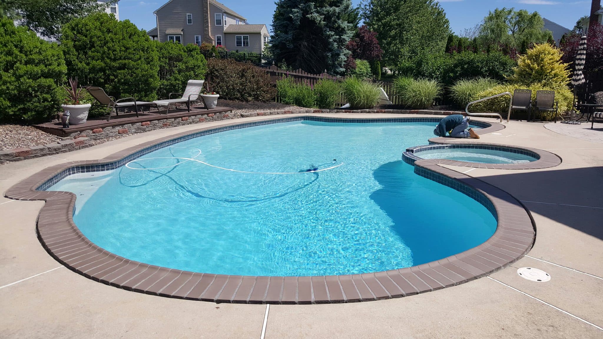 Freeform pool with attached spa and bullnose coping in mountain-view backyard