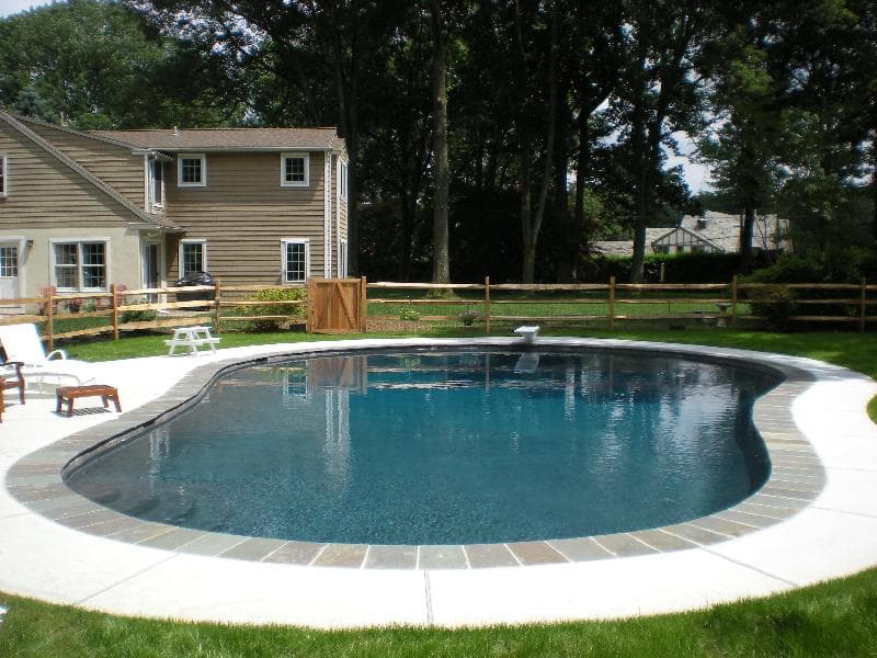 Lazy-L pool with French gray plaster and bluestone coping behind clapboard home