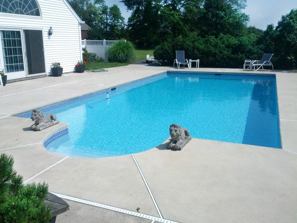 Lazy-L pool with cantilever broom-finish deck and lion statues at deep end