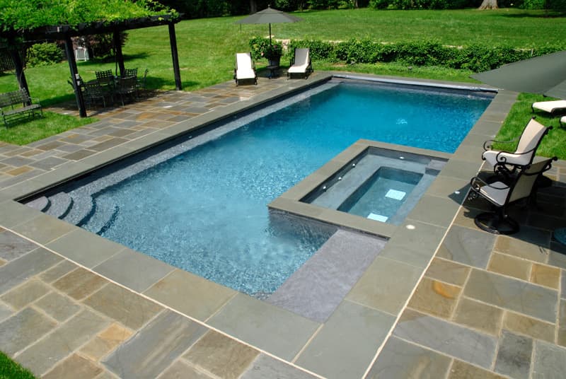 Rectangular pool with attached spa, flagstone deck and pergola dining area