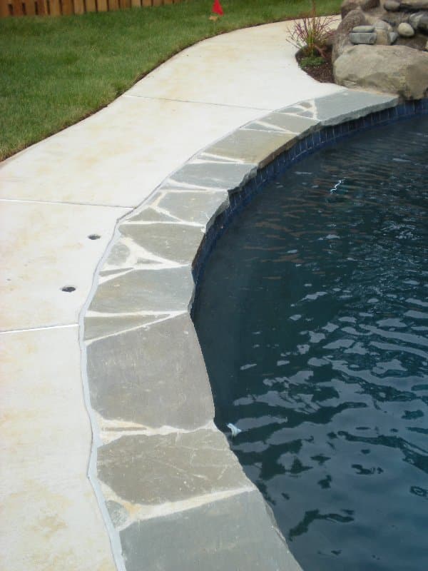 Bluestone flagstone coping detail with blue waterline tile — Premier Pool Renovations