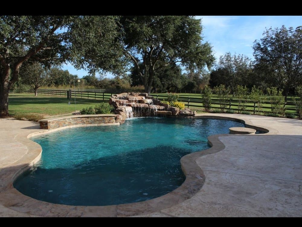 Freeform pool with stone boulder waterfall in Bedminster — Premier Pool Renovations