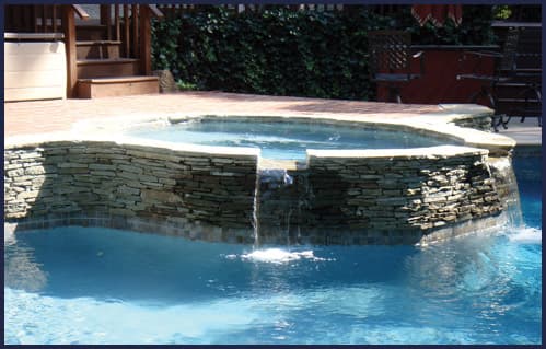 Stacked stone raised spa with sheer descent waterfalls — Premier Pool Renovations