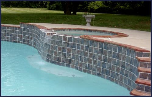 Raised pool wall with sheer descent waterfall and tile — Premier Pool Renovations